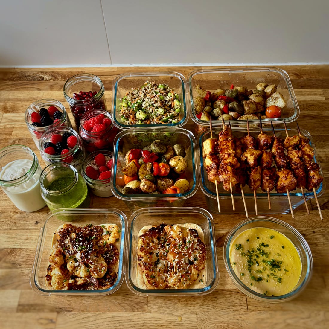 Verschiedene Meal-Prep-Boxen mit Salaten, Spießen und Blumenkohl